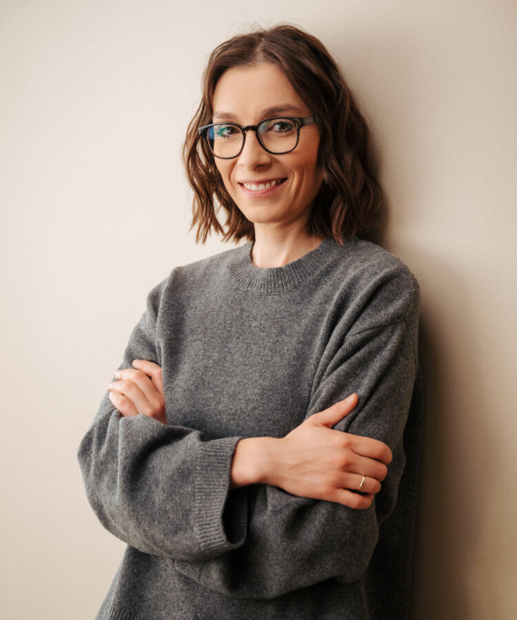 Portrait von Cecilia Barriga im grauen Pullover vor Wand